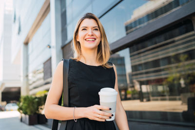 Portrait of smiling young woman standing outdoors