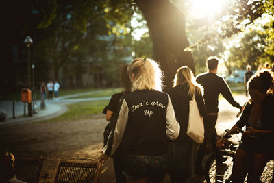 Rear view of people walking on road