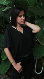 Portrait of beautiful woman standing with leaves