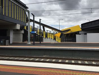 Railroad station platform against cloudy sky