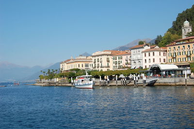 View of boats in town against blue sky