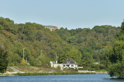 Scenic view of river by building against clear sky