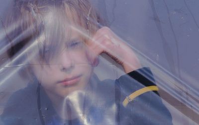 Portrait of a kid, looking through plastic film