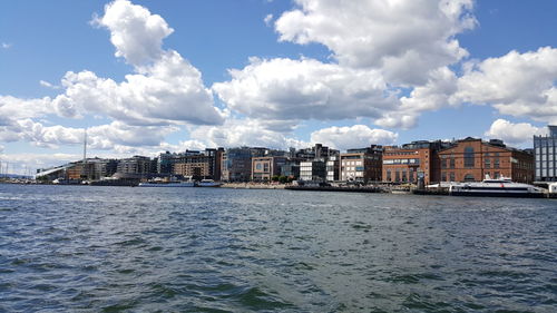 Buildings in city against cloudy sky