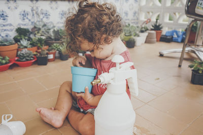 Full length of cute baby girl sitting on floor at home