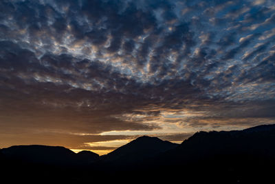 Scenic view of silhouette mountains against dramatic sky