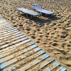 Lounge chairs by boardwalk at beach