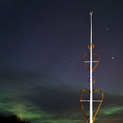 Low angle view of heart shape on pole against dramatic sky at night