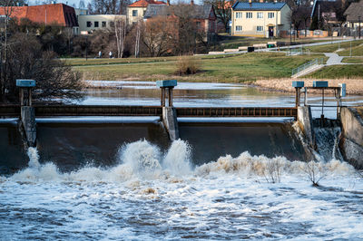 Spring flood water flows over the locks on the berze river in dobele city, latvia