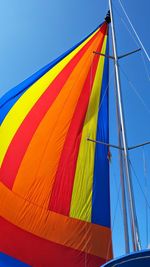 Low angle view of colorful boat canvas against clear blue sky