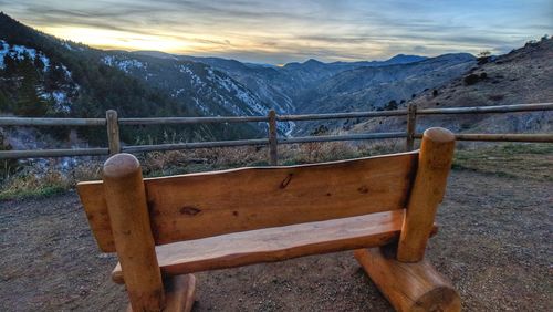 Bench in park against sky
