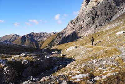 Scenic view of snowcapped mountains against sky man hiking alpine