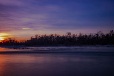 Scenic view of lake against romantic sky during sunset