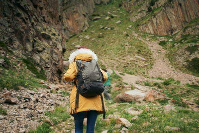 Rear view of woman standing amidst plants