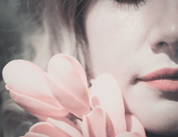 Close-up of beautiful woman holding pink flower