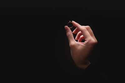 Close-up of human hand against black background