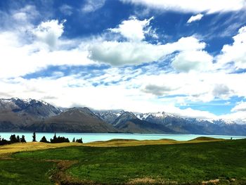 Scenic view of field and mountains against sky