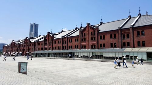 People walking on street against buildings in city