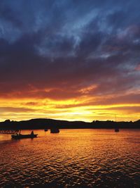 Scenic view of sea against cloudy sky at sunset