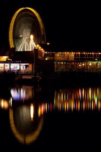 Illuminated bridge over river at night