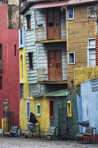 Full length of man sitting on street against buildings in city