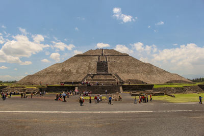 Group of people in front of built structure against sky