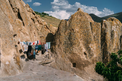 People on rock formations against sky