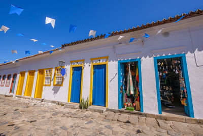 Low angle view of multi colored building against clear blue sky