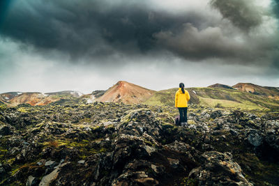 Rear view of woman standing on rock