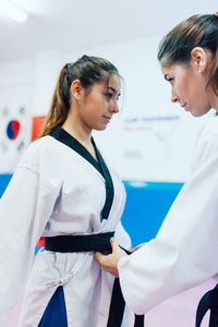 Young woman standing in front of two women