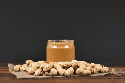 Close-up of drink in glass jar on table against black background