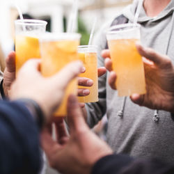 Midsection of people toasting drinks