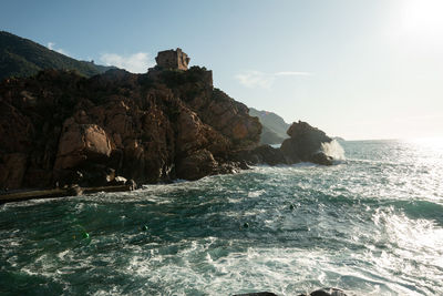 Rock formations in sea against sky