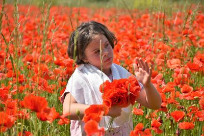 Young woman picking flowers in field