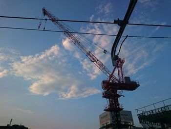 Low angle view of crane against sky