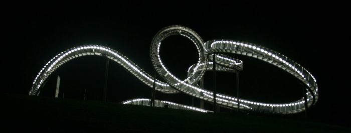 Illuminated ferris wheel against sky at night