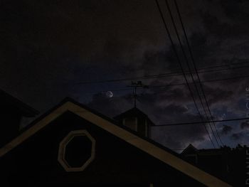 Low angle view of silhouette house against sky at dusk