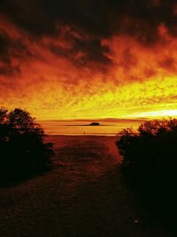 Scenic view of sea against dramatic sky during sunset