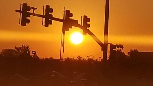 Silhouette cross against sky during sunset