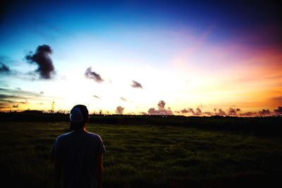 Scenic view of grassy field against sky at sunset