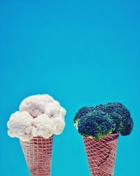 Close-up of ice cream cone against blue sky