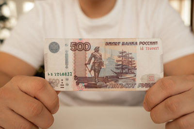 A close-up man holds in his hands an unfolded bill with a face value of 500 rubles. russian money.