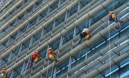 Low angle view of people working on metal structure