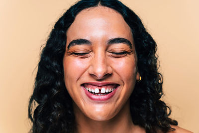 Close-up of young woman against yellow background