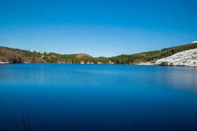 Scenic view of lake against clear blue sky