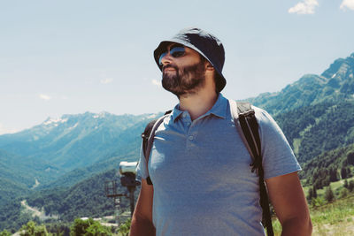 Portrait of young man standing against mountain