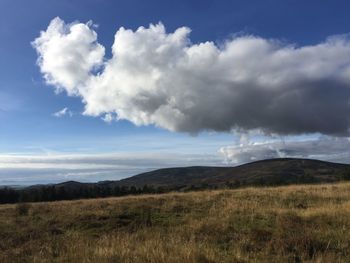 Countryside landscape against cloudy sky