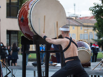 Midsection of man playing guitar in city