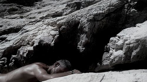 Full length of woman relaxing on rock