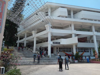 People walking on modern building in city